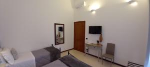 - une chambre avec un lit, un bureau et une télévision dans l'établissement B&B Acanto Lecce, à Lecce