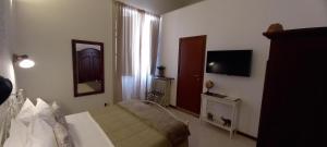 Habitación de hotel con cama, TV y habitación en Dimora di Acanto - Lecce, en Lecce 19 fotos más