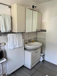a white bathroom with a sink and a mirror at Felsenblick Himmelsfels in Geislingen an der Steige