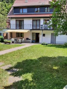 a large white house with a balcony and a yard at Felsenblick Himmelsfels in Geislingen an der Steige
