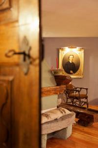 a room with a portrait of a man with a candle at Locanda La Brenva - Estella Hotel Collection in Courmayeur
