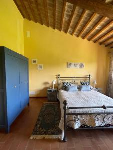 a bedroom with a bed and a yellow wall at Podere Umbro in Città della Pieve