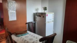 eine Küche mit einem Tisch und einem weißen Kühlschrank in der Unterkunft Stan za iznajmuvanje so parking,blisku do centar. in Kumanovo