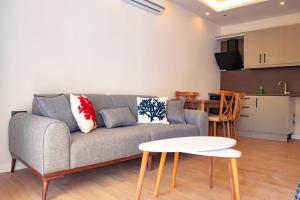 a living room with a couch and a table at Cozy apartment with balcony in Bodrum City
