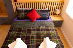 a bed with a plaid blanket and pillows on it at Cozy apartment with balcony in Bodrum City