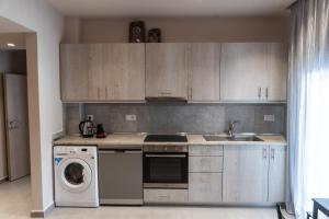 a kitchen with a washing machine and a sink at Anastasia's Apartments Halkidiki in Nea Plagia +2 photos