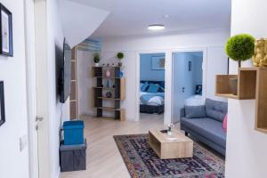 sala de estar con sofá y cama en O&O Group - The SeaGate Estate suites - Suite 2, en Rishon LeZion