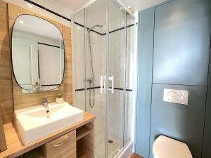 La salle de bains est pourvue d'un lavabo et d'une douche. dans l'établissement Sur la plage Valentin Beach Home - T3bis, à Batz-sur-Mer