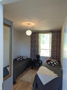een slaapkamer met 2 bedden, een spiegel en een raam bij Kartanonrinteen Amanda in Teijo