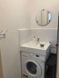 ein Badezimmer mit einem Waschbecken und einer Waschmaschine in der Unterkunft Dzīvoklis pie parka un jūras in Liepāja