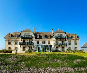 a large house on a hill with a grass field at Valentin Beach Home ! un duplex sur la plage in Batz-sur-Mer