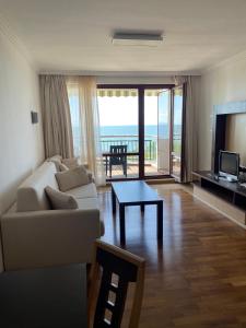 a living room with a couch and a table at private apartments in Emerald in Ravda