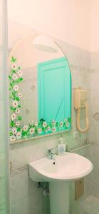 a bathroom with a sink and a blue mirror at Casa Fiore Olbia in Olbia +28 photos