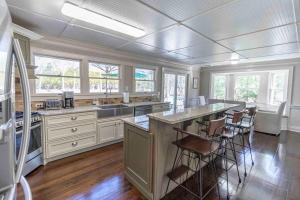 a large kitchen with a large island with bar stools at Hamptons Retreat: Near Beaches, Restaurants, Wineries in Hampton Bays