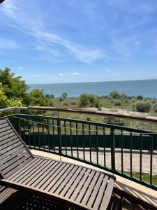 a wooden bench sitting on a balcony overlooking the ocean at private apartments in Emerald in Ravda