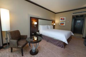 ein Hotelzimmer mit einem Bett, einem Stuhl und einem Tisch in der Unterkunft Holiday Inn Kuwait Al Thuraya City, an IHG Hotel in Kuwait