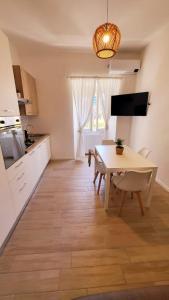 - une cuisine et une salle à manger avec une table et des chaises dans l'établissement MARÈ Terracina Apartments, à Terracine