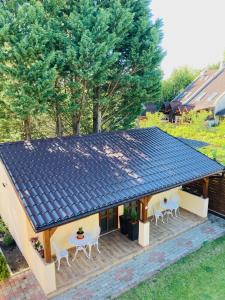 ein Haus mit einem Sonnendach auf einer Terrasse in der Unterkunft Mimi Apartments in Zamárdi