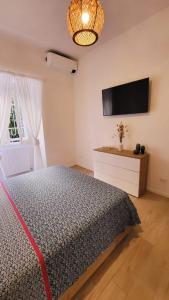 - une chambre avec un lit et une télévision à écran plat dans l'établissement MARÈ Terracina Apartments, à Terracine