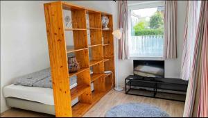 um quarto com uma estante de livros de madeira ao lado de uma cama em 1-Zimmer Apartment im Zentrum em Wilhelmshaven