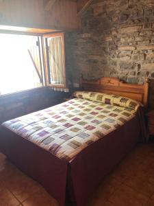 Bett in einem Zimmer mit einer Steinmauer in der Unterkunft apartamentos casa botero in Sarvisé