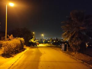 una calle vacía por la noche con un semáforo en QB Elegant Villa Bahria Town, en Rawalpindi