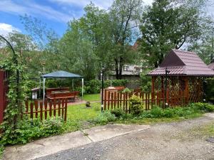 a garden with a wooden fence and a gazebo at Wynajem Pokoi gościnnych Jaś i Małgosia in Zakopane