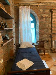 a bedroom with a bed in a brick wall at Dabakhnebi in Telavi