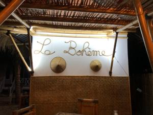 a sign with the words be blonde on a wall at La Bohème in Gili Air