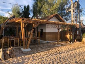 een gebouw met een rieten dak op het strand bij La Bohème in Gili Air