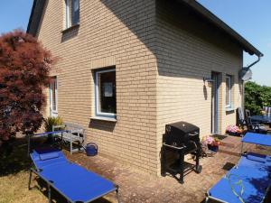 a grill and picnic tables in front of a house at Ferienhaus Undine, ruhige Lage, Nähe zur Altstadt, nur 500 m zur Müritz mit Strand, mit Parkplatz und Fahrradhäuschen in Waren