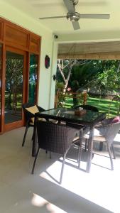 eine Terrasse mit einem Tisch und Stühlen auf einer Veranda in der Unterkunft Bali Cottage Sambirenteng in Buleleng