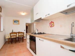 uma cozinha com um lavatório e um fogão forno superior em Villa Lobra em Massa Lubrense