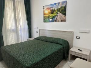 Un dormitorio con una cama verde y una foto en la pared en Hotel Barbarossa en Porto Azzurro