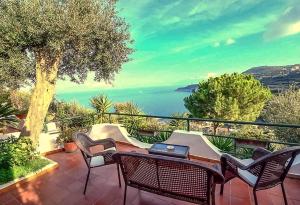 a table and chairs on a balcony with a view of the ocean at Villa Lobra in Massa Lubrense