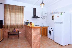 een keuken met een witte koelkast en een magnetron bij Cortijo Algarrobo Casa de Campo tranquila in Carboneras