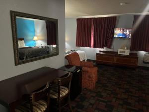 ein Hotelzimmer mit einem Spiegel und einem Schlafzimmer in der Unterkunft Rodeway Inn in Whitehall