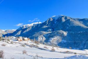 a snow covered mountain with a house in front of it at Belle maison chaleureuse, lumineuse dans la nature in Eygliers