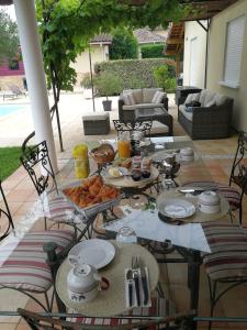 een tafel met borden eten op een patio bij Au Doux Repos in Lucbardez-et-Bargues