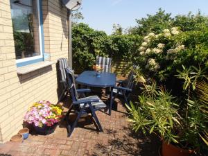 a patio with two chairs and a table with flowers at Ferienhaus Undine, ruhige Lage, Nähe zur Altstadt, nur 500 m zur Müritz mit Strand, mit Parkplatz und Fahrradhäuschen in Waren