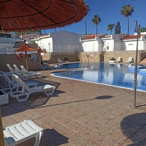 una piscina con sedie a sdraio e un resort di Bruna's house ad Adeje