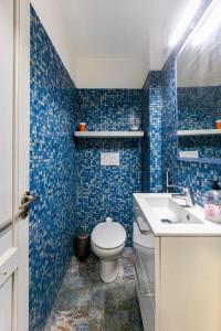 W wyłożonej niebieskimi kafelkami łazience znajduje się toaleta i umywalka. w obiekcie Estudio privado in Los Gigantes w mieście Acantilado de los Gigantes