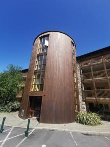 un gran edificio de madera con una puerta en un aparcamiento en sleeps 4 balcony overlooking harbour Walkers /cyclists /water paradise, en Westport