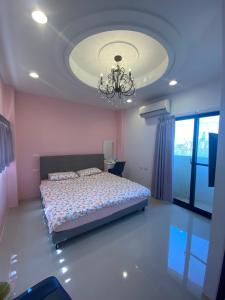 een slaapkamer met een bed en een kroonluchter bij 葳葳民宿 in Magong