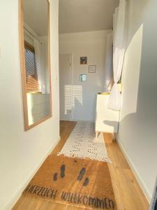 pasillo con espejo y alfombra en el suelo en Tiny Haus Straußenblick 2, en Bad Fallingbostel
