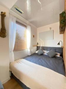 Schlafzimmer mit einem großen Bett und einem Fenster in der Unterkunft Tiny Haus Straußenblick 2 in Bad Fallingbostel