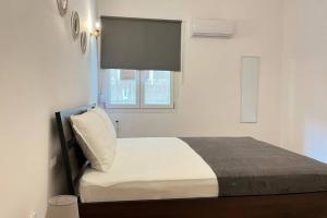 een kleine slaapkamer met een bed en een raam bij Pame Apartment Best Fit For 4 Guests in Athene