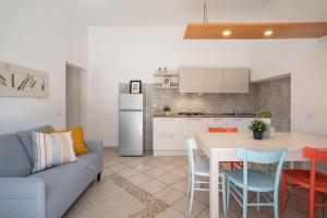 a kitchen and living room with a table and a couch at Le Case di Salvia in San Vincenzo