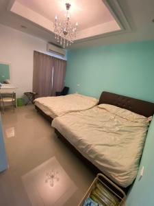 een slaapkamer met een bed en een kroonluchter bij 葳葳民宿 in Magong
