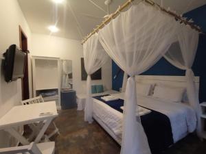 a bedroom with a bed with a canopy at Magias de Paraty Ecopousada in Paraty